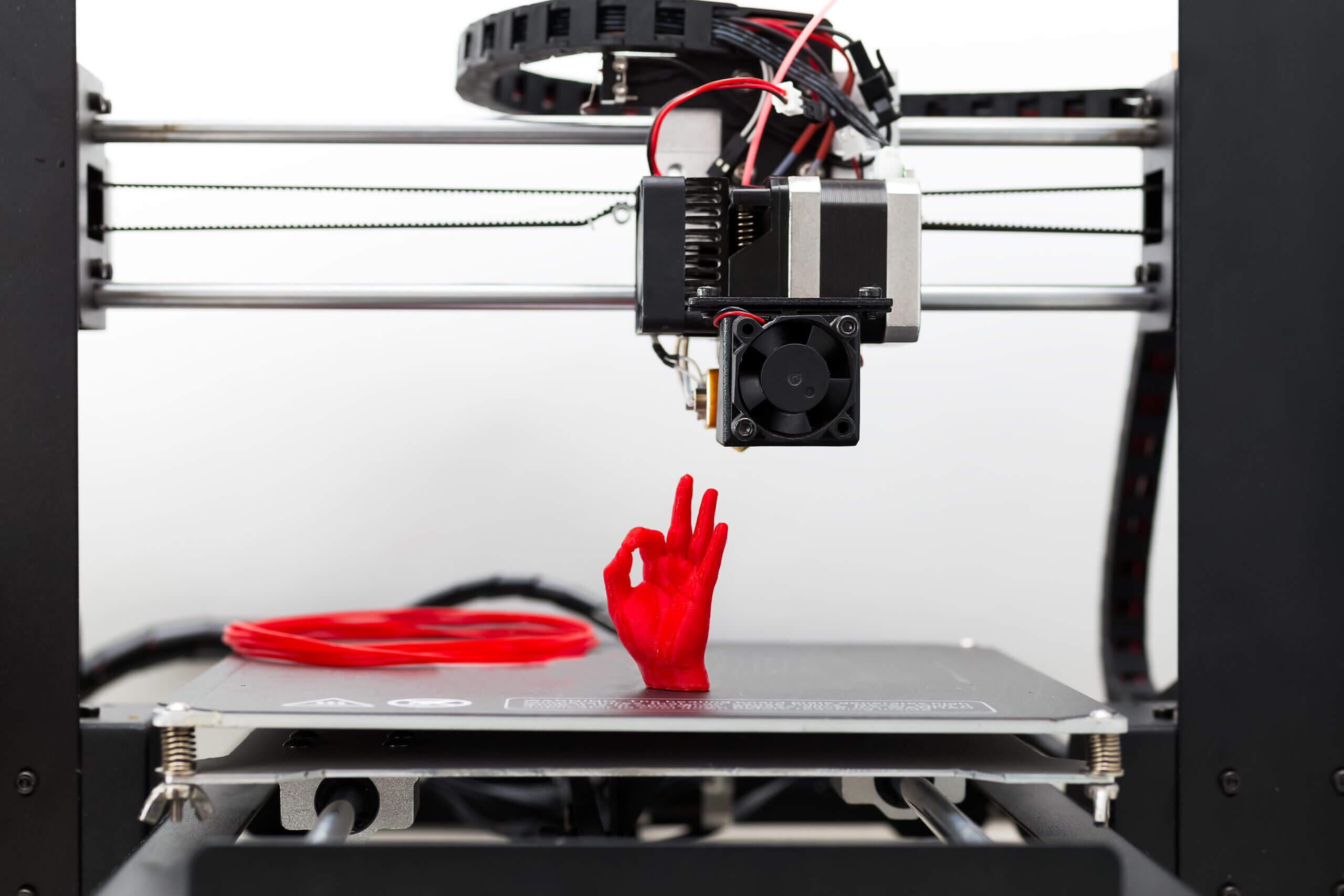 Detail of a 3D printer printing with a red  filament